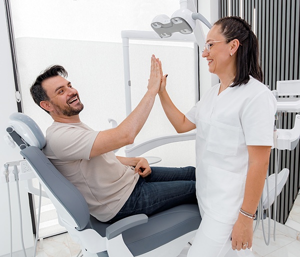 Patient high-fiving dental team member