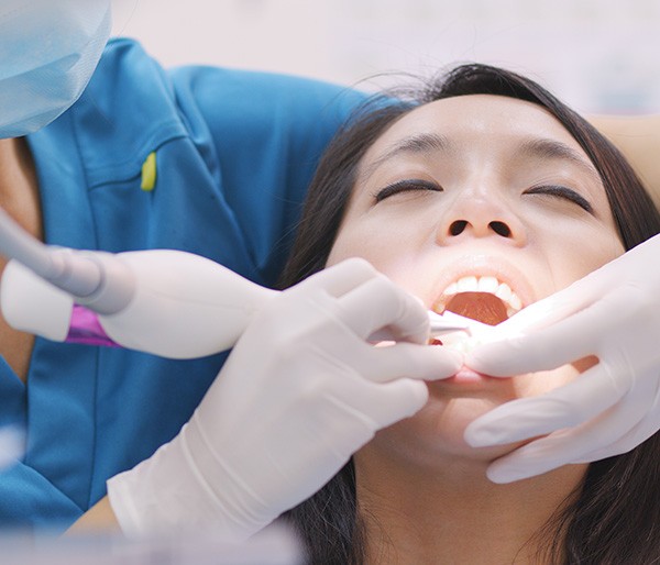 Dentist cleaning patient’s gums