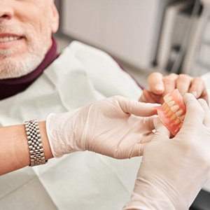 a patient receiving his new dentures