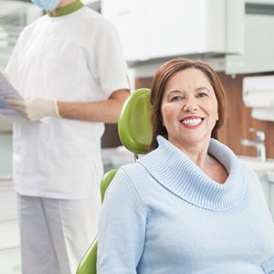 a dental patient smiling after replacing her missing teeth