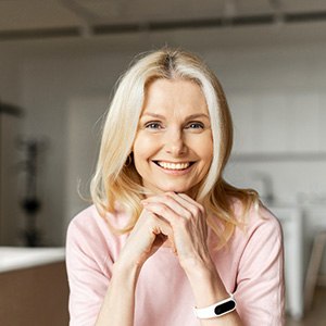 Blonde woman sitting in kitchen and smiling