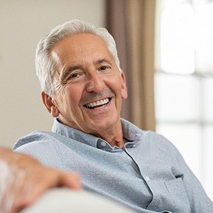 Senior man sitting on a couch and smiling